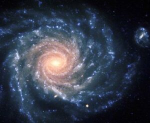 A spiral-shaped galaxy in the universe. with blue and orange spirals and a bright yello center.