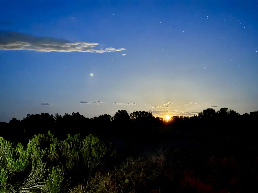 Moonrise over the Colorado landscape with clouds and stars