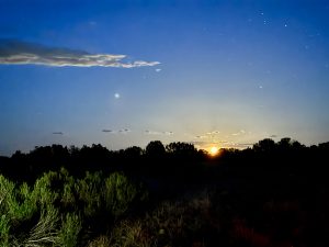 Moonrise over the Colorado landscape with clouds and stars